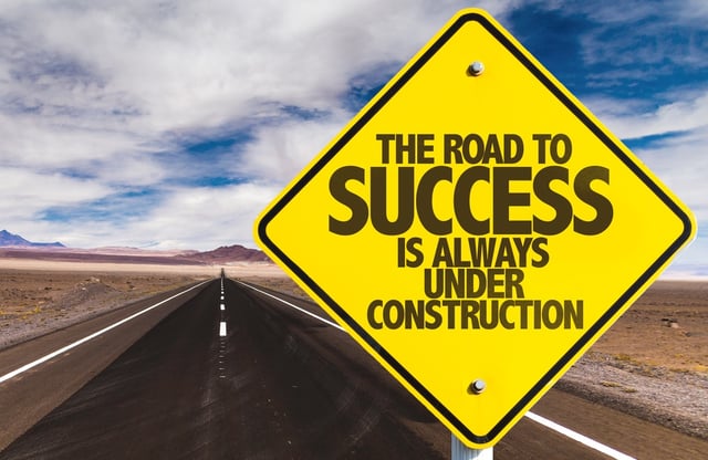 The Road to Success is Always Under Construction sign on desert road.jpeg